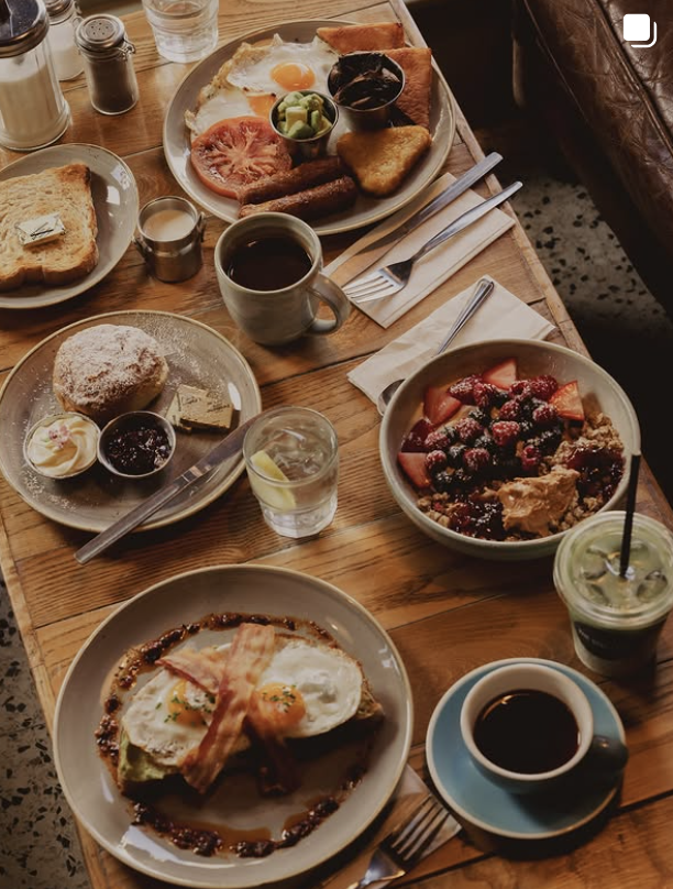 Overhead spread of a full Ulster fry, fruit bowl, scone and coffees